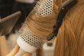 pexels-photo-14615064-14615064 Detailed view of hairstylist curling hair in salon using a round brush and hairdryer.