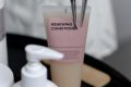 pexels-photo-7440059-7440059-1 Stylish arrangement of haircare products with renewing conditioner and clips on a tray.