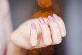 pexels-photo-939836-939836 A close-up of a woman's hand displaying a stylish pink glitter manicure, highlighting nail art details.